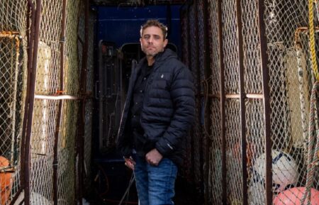 Captian Jake Anderson poses between pots on the deck of the FV Titan Explorer