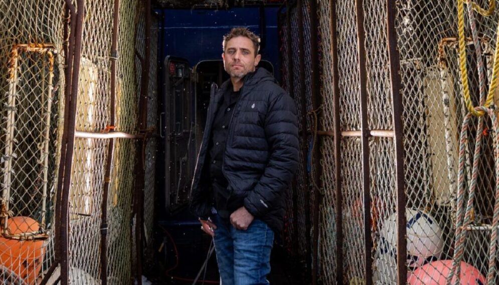 Captian Jake Anderson poses between pots on the deck of the FV Titan Explorer