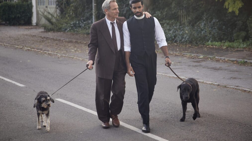 Robson Green as Geordie Keating and Rishi Nair as Alphy Kottaram walking dogs in Grantchester