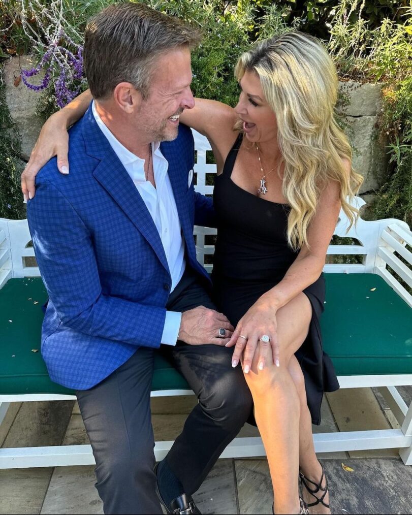 Alexis Bellino and John Janssen sitting on a bench.