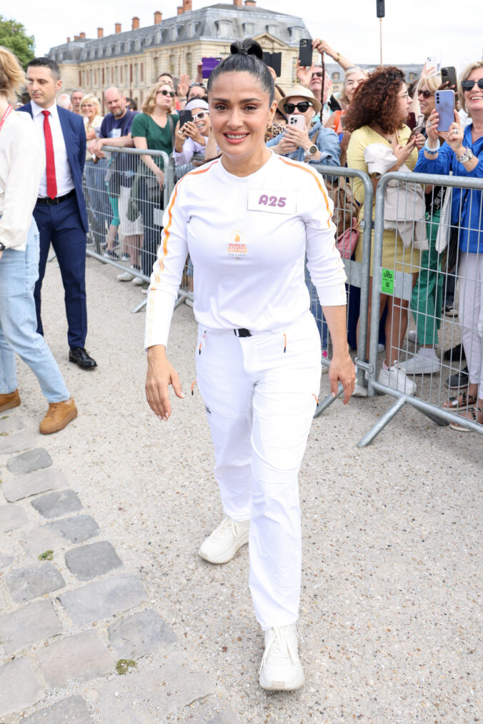 Salma Hayek runs during the Paris Olympics torch relay on July 23, 2024 in Versailles, France. Paris will host the Summer Olympics from July 26 to August 11, 2024.