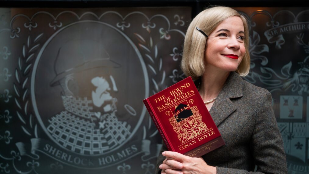 Lucy Worsley holding a copy of The Hound of the Baskervilles in front of The Sherlock Holmes Pub in London__