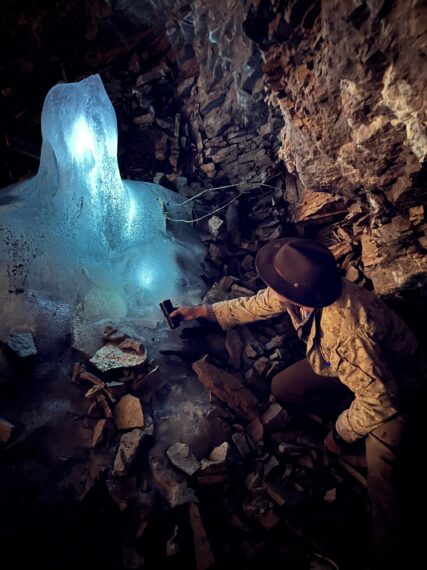 Eric Drummond examines ice stalagmite in cave.