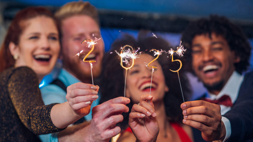 Young happy people looking at sparklers in their hands