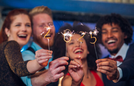 Young happy people looking at sparklers in their hands