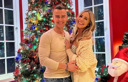 Joey Lawrence and Samantha Cope in front of a christmas tree.