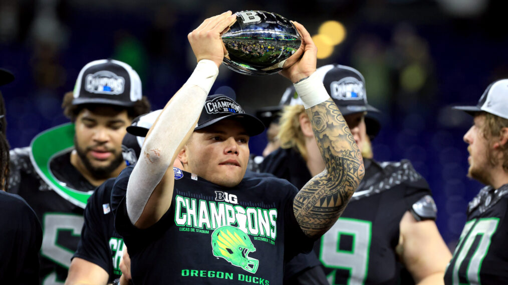 Dillon Gabriel #8 of the Oregon Ducks celebrates with the trophy after the team's 45-37 win against the Penn State Nittany Lions in the 2024 Big Ten Football Championship at Lucas Oil Stadium on December 07, 2024 in Indianapolis, Indiana.