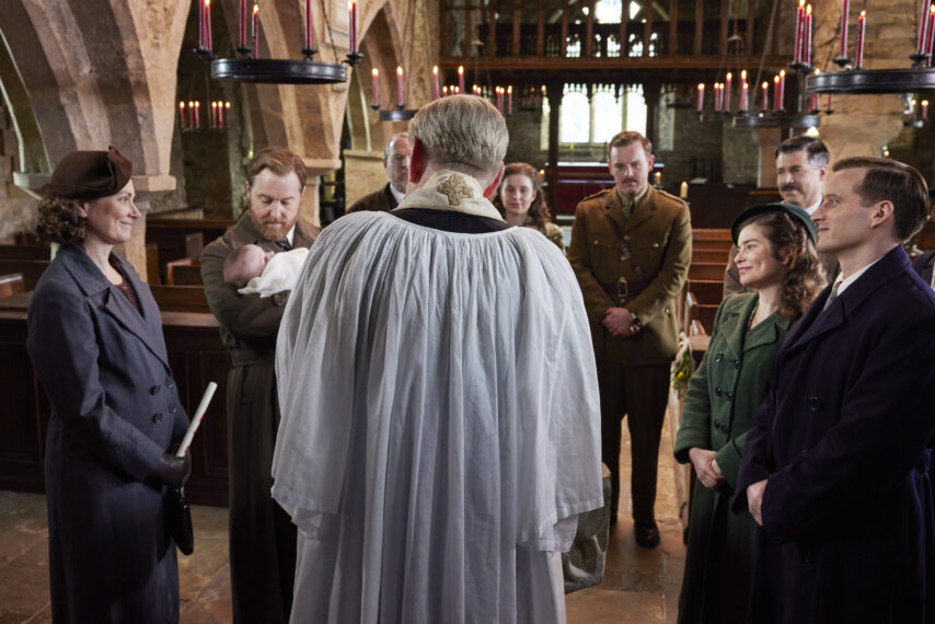 Shown from left to right: Mrs. Hall (Anna Madeley), Siegfried Farnon (Samuel West), Richard Alderson (Tony Pitts), Jenny Alderson (Imogen Clawson), Tristan Farnon (Callum Woodhouse), James Herriot Sr (Drew Cain), Helen Herriot (Rachel Shenton), James Herriot (Nicholas Ralph) in 'All Creatures Great and Small' Season 5 Episode 3 - 'Homecoming'