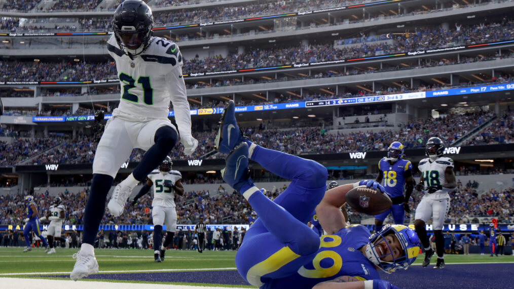 Tyler Higbee #89 of the Los Angeles Rams falls after his catch for a touchdown in front of Devon Witherspoon #21 of the Seattle Seahawks, to trail 14-10, during the second quarter at SoFi Stadium on January 05, 2025 in Inglewood, California.