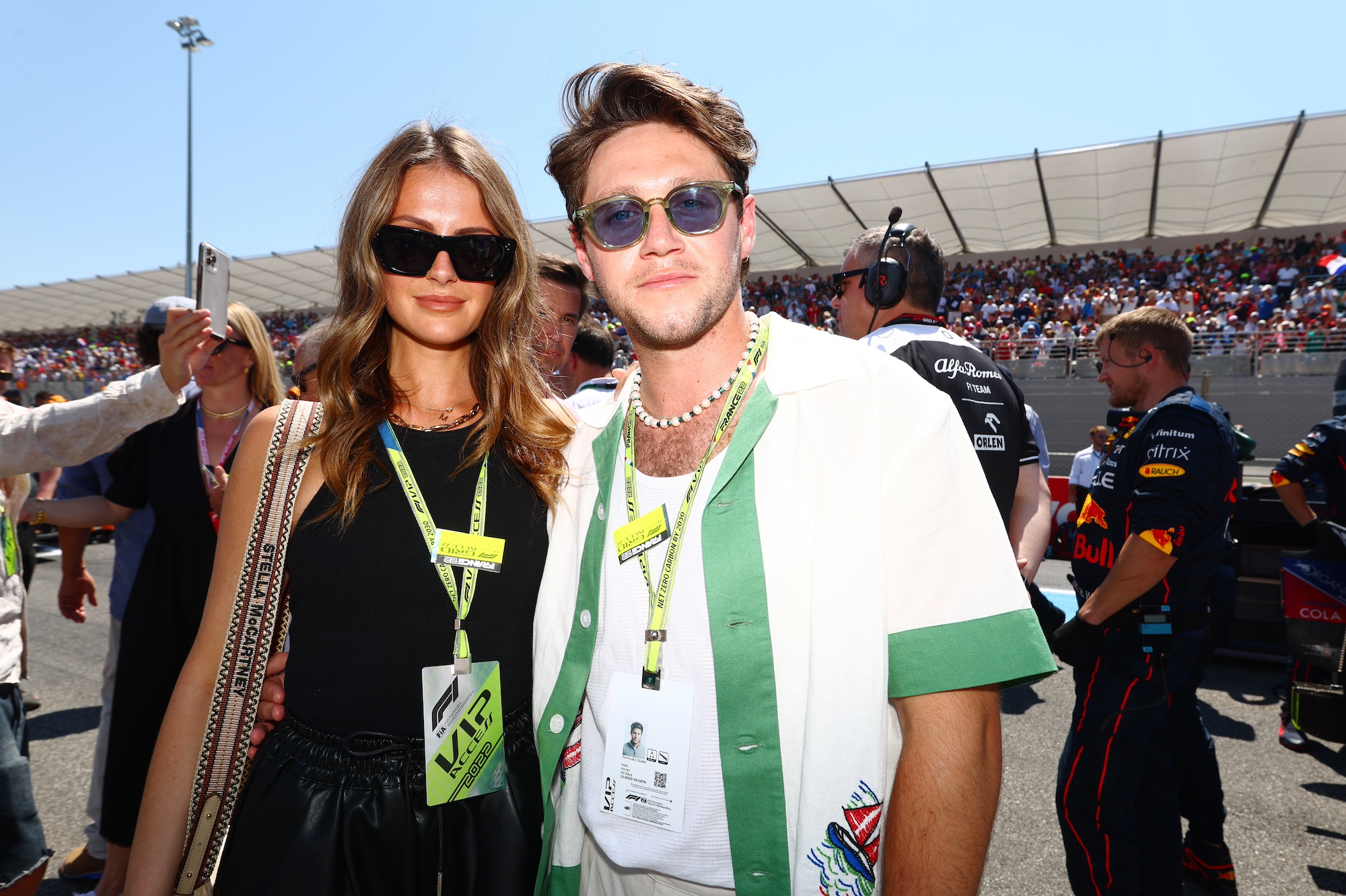 Niall Horan and Amelia Woolley pose for a photo on the grid during the F1 Grand Prix